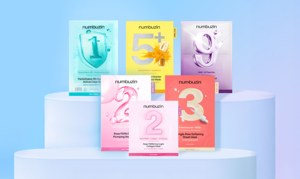 Exhibición de mascarillas faciales numbuzin organizadas por números sobre pedestales blancos. Cada mascarilla representa una solución específica para la piel, como calma, luminosidad, poros o firmeza, reflejando el sistema numerado de numbuzin que facilita la elección del cuidado de la piel coreano según la necesidad cutánea.