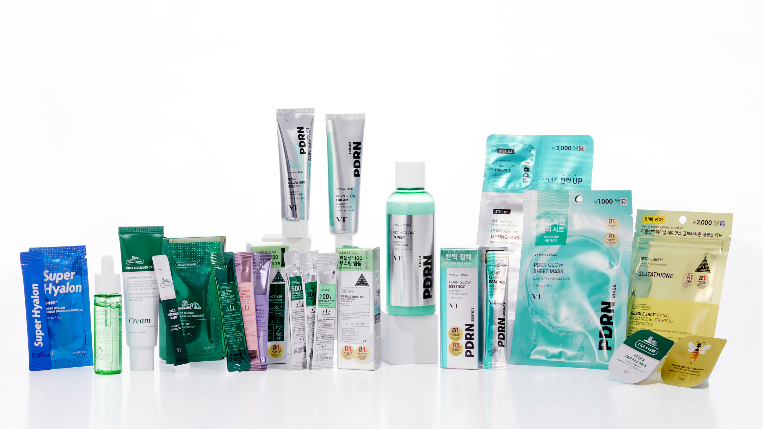 An assortment of VT skincare products arranged neatly against a white background, including PDRN Glow toner, essence, and cream, Cica line creams and ampoules, and various pouch-type masks and patches such as lifting masks and glutathione care items.