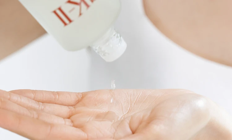 sk-ii 使ってる人の肌をイメージさせる、SK-II フェイシャルトリートメントエッセンスを手のひらに出しているシーン。さらっとした発酵化粧水のテクスチャーが分かるビジュアル。
