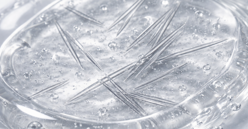 Close-up view of reedle shot texture showing micro-spicule structures suspended in a clear gel formula.