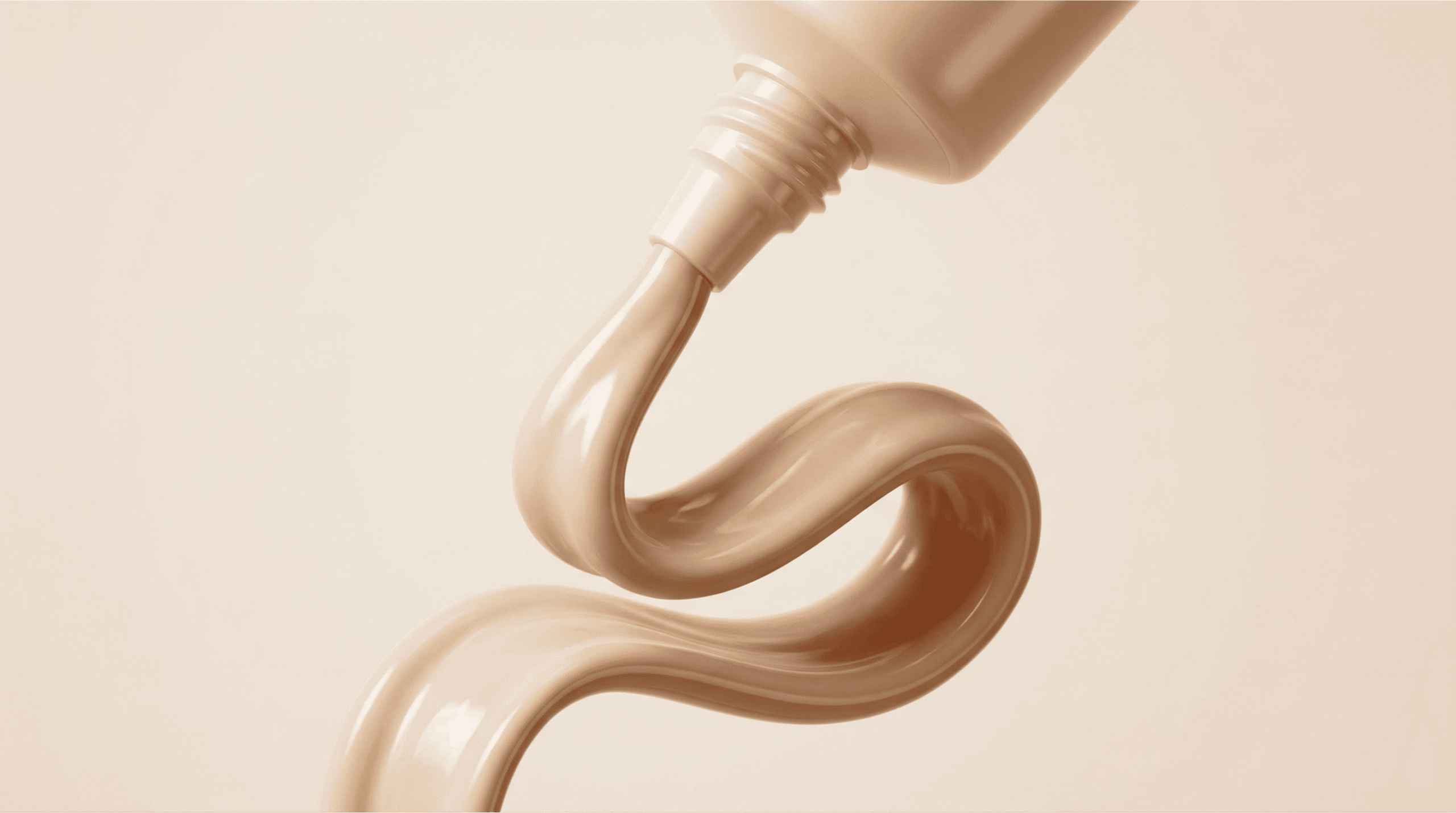A close-up shot of beige tinted sunscreen being squeezed out of a tube in a smooth, wavy ribbon. The creamy texture and flesh-toned pigment highlight the product's coverage and sun protection.