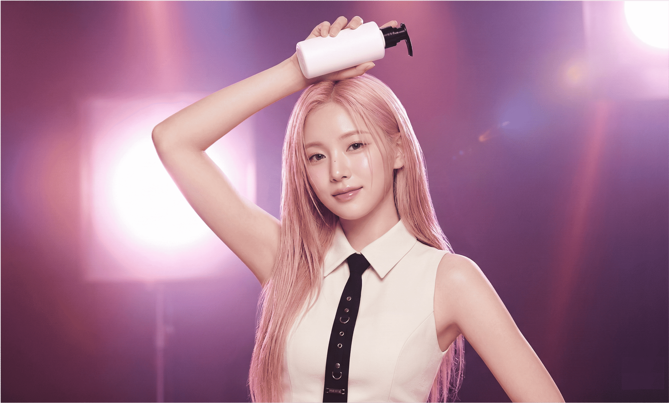 K-pop idol with pink hair applying hair care product on stage-style lighting background, illustrating a K-pop idol hair care routine.